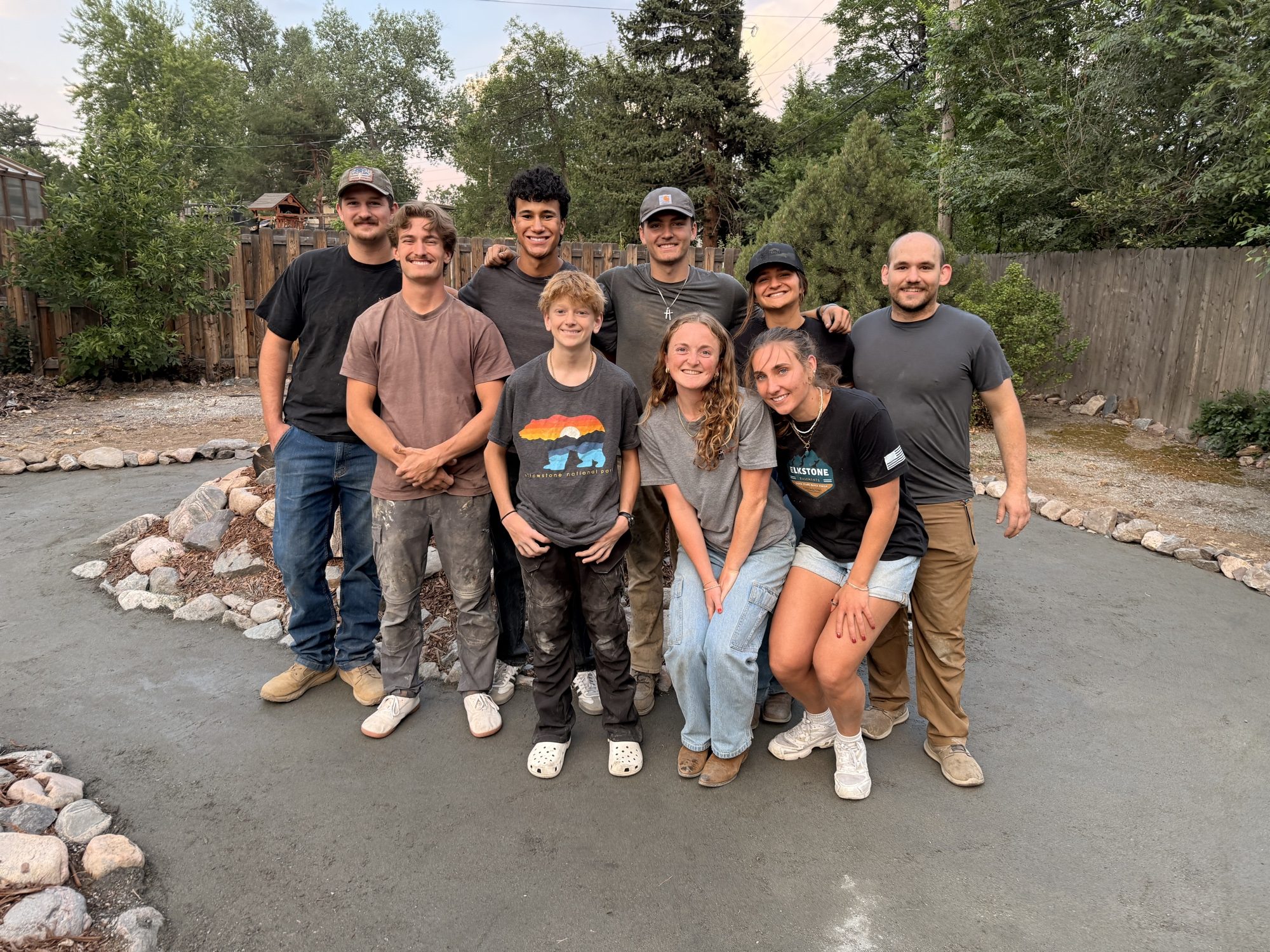 The crew standing together on a finished garden path at the end of a workday.