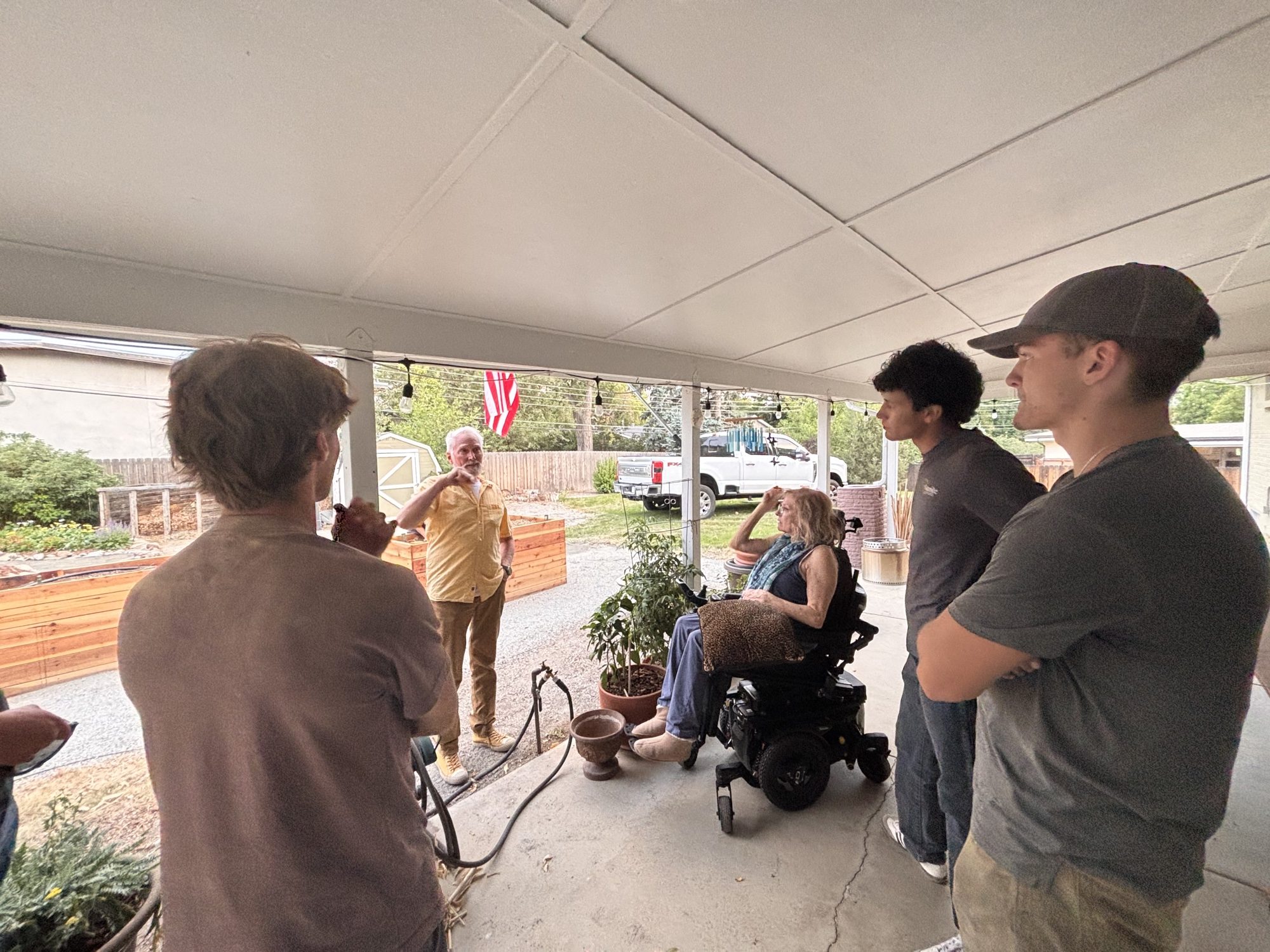 Tom and Tracey under their carport with the crew gathered around, before the work started.